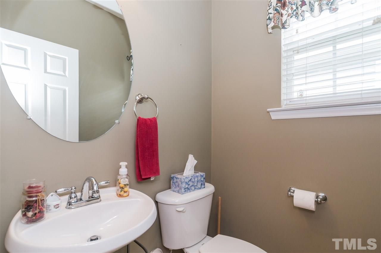 8417 Whisper Ridge Place Raleigh, NC 27613 - Photo 10 of 24 a bathroom with a toilet a sink and mirror