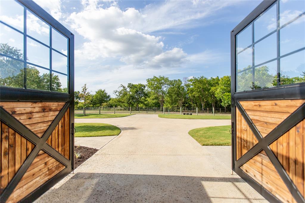 5000 T W King Road Southlake, TX 76092 - Photo 22 of 40 Oversized custom barn doors open directly from the alleyway towards the pastures creating seamless access and natural flow.