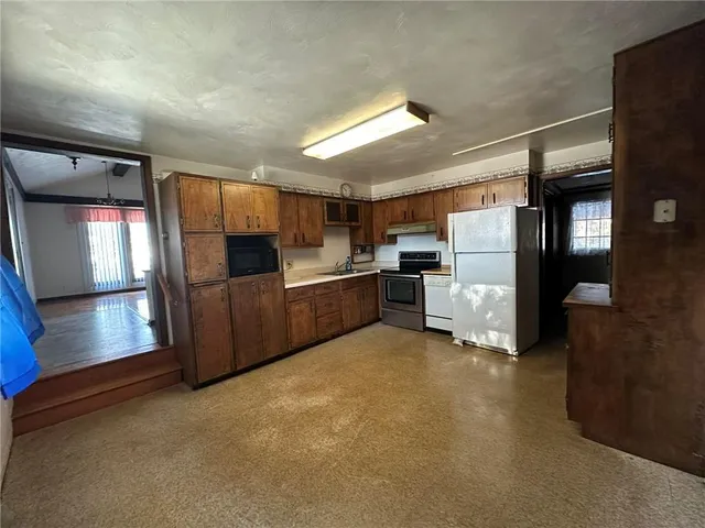 a view of a kitchen with refrigerator and microwave