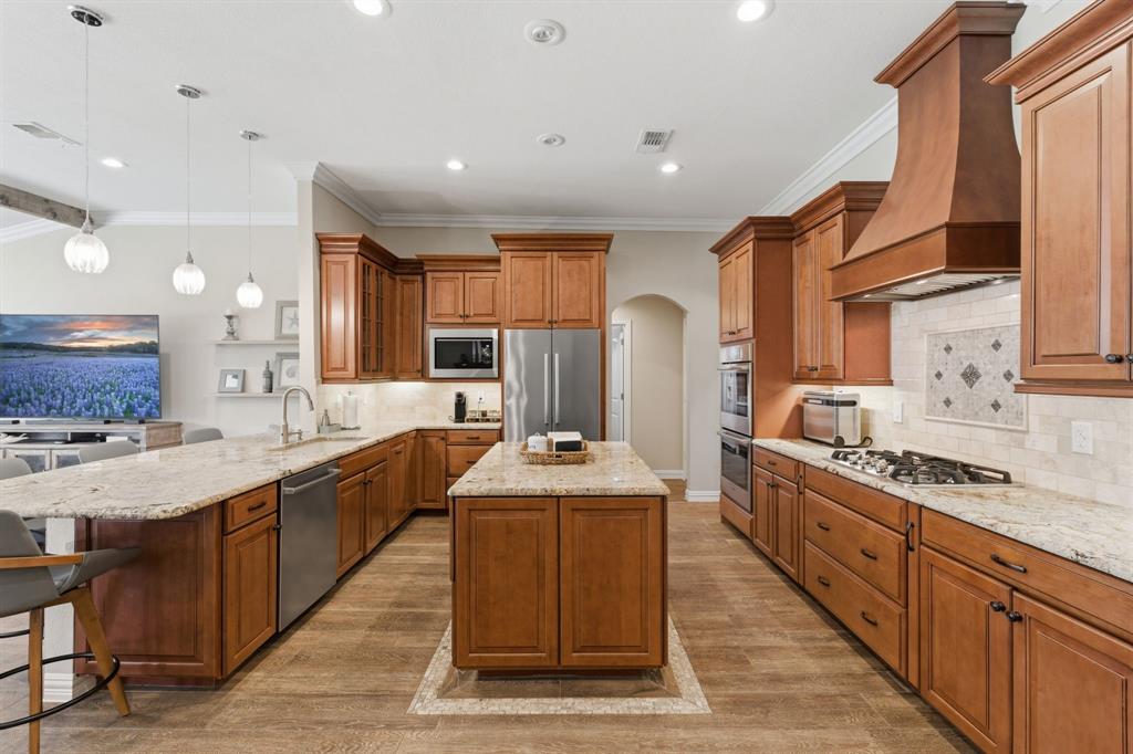 10390 Ridgecrest Street Frisco, TX 75033 - Photo 16 of 40 a large kitchen with stainless steel appliances granite countertop a stove a sink dishwasher and a oven with cabinets