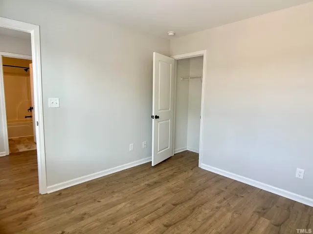 an empty room with wooden floor and closet