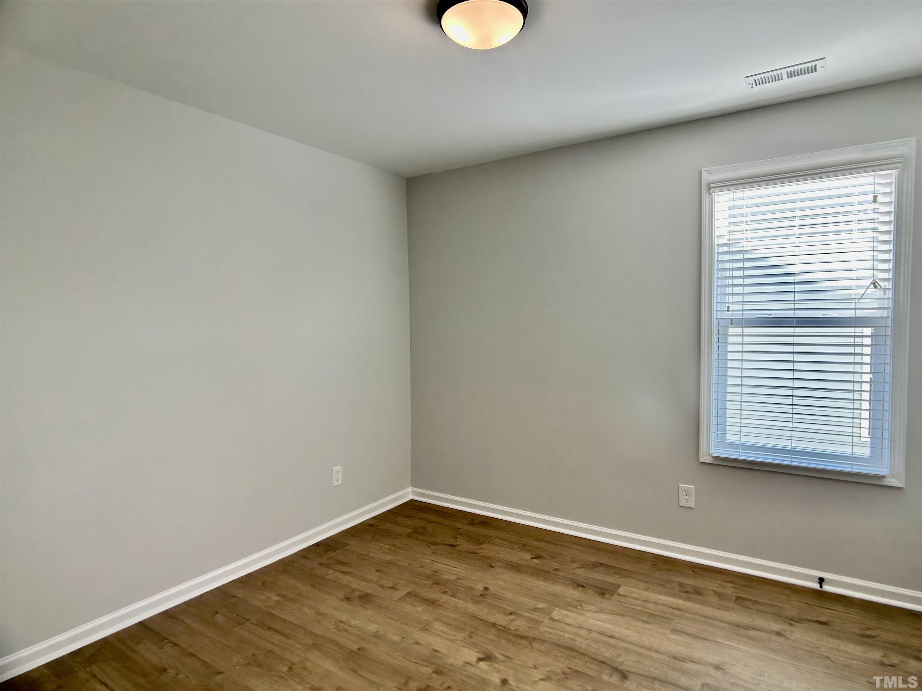 150 Greenview Street Clayton, NC 27520 - Photo 13 of 23 a view of an empty room with wooden floor and a window