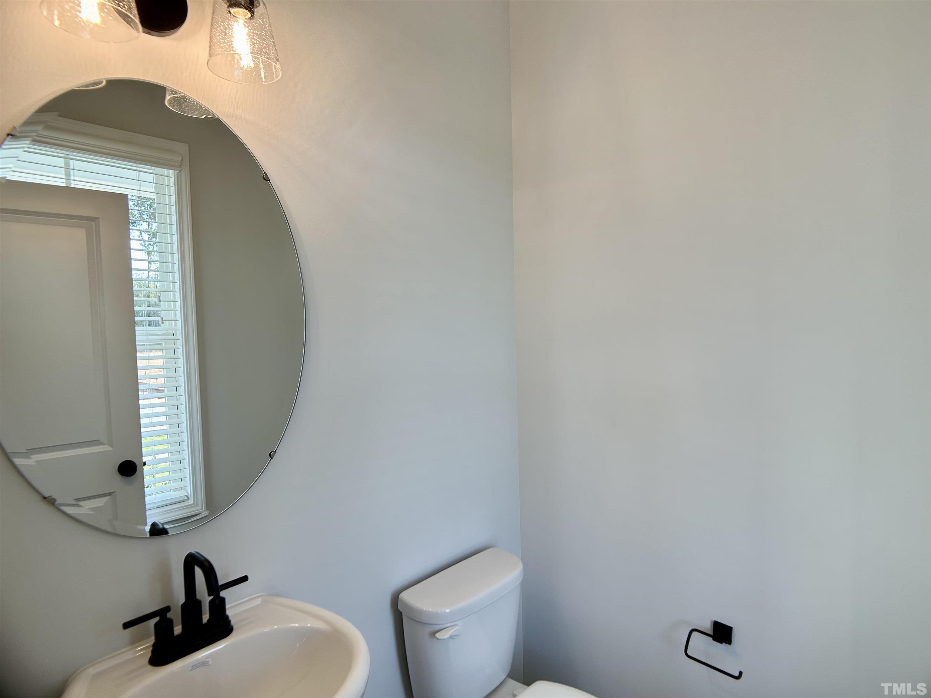 150 Greenview Street Clayton, NC 27520 - Photo 15 of 23 a bathroom with a toilet a sink and mirror