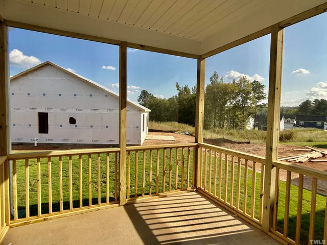 a view of a balcony with wooden floor and fence