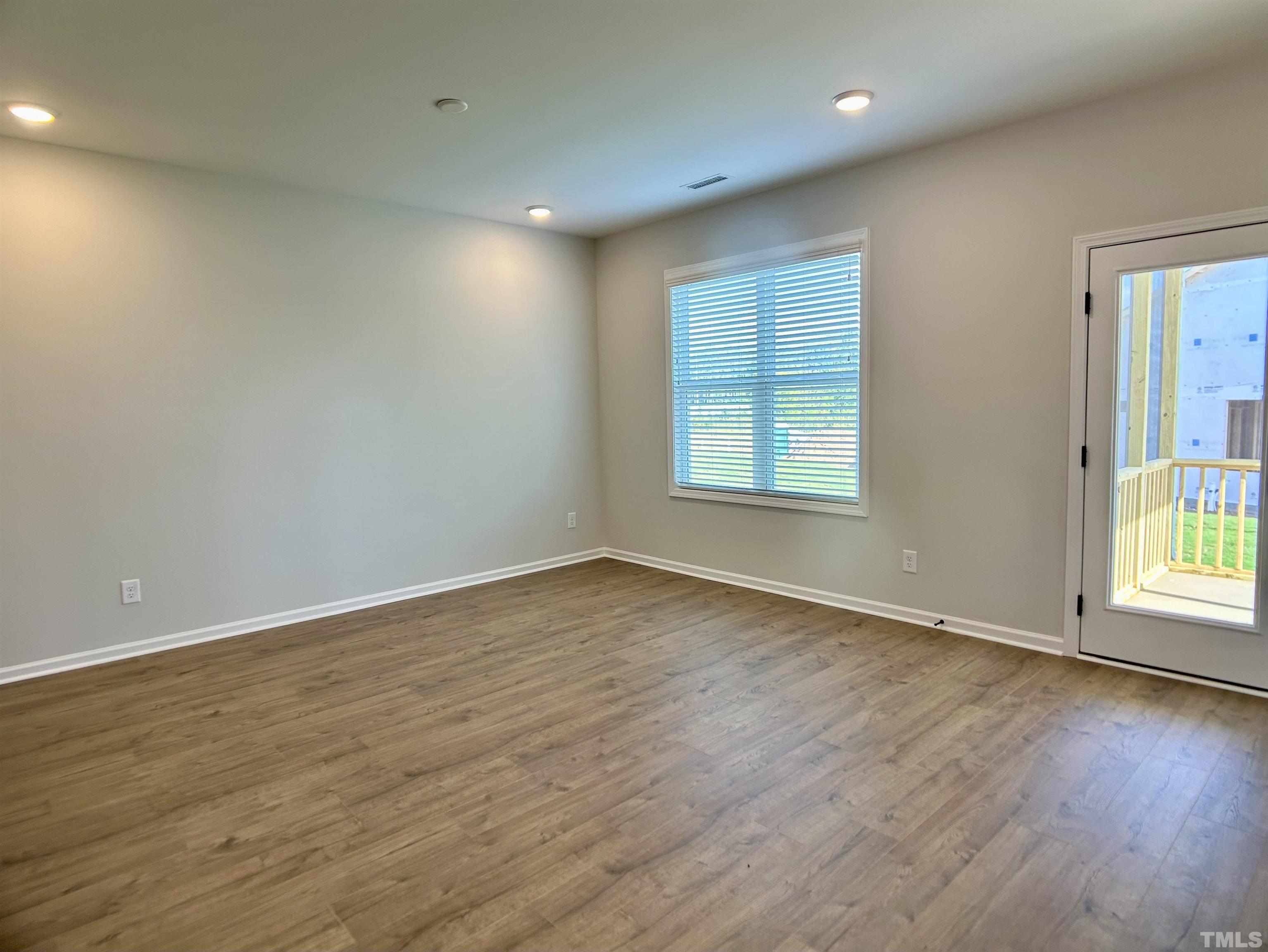 150 Greenview Street Clayton, NC 27520 - Photo 5 of 23 an empty room with wooden floor and windows