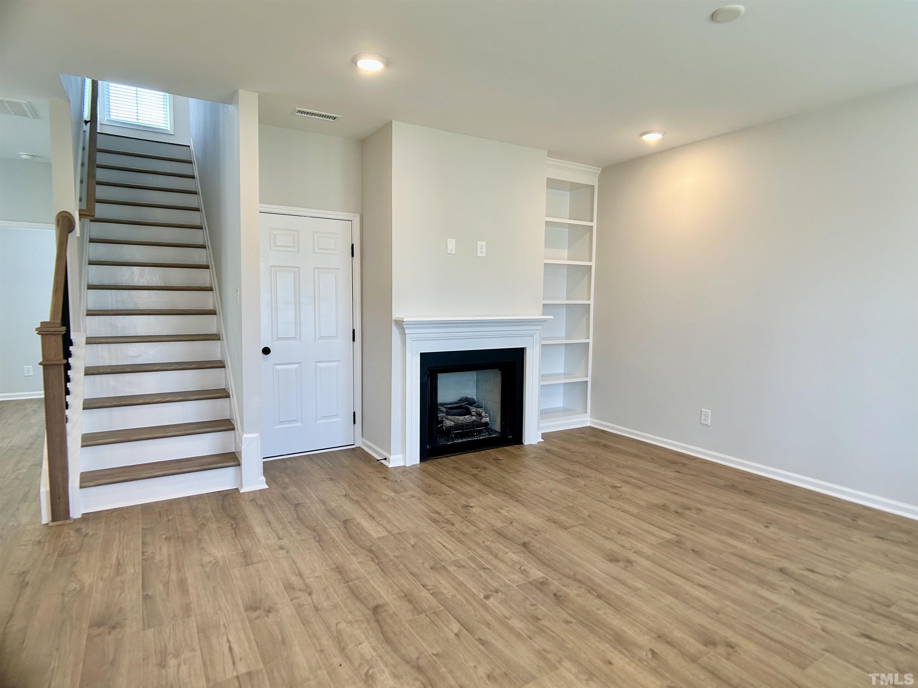 150 Greenview Street Clayton, NC 27520 - Photo 6 of 23 a view of an empty room with a fireplace and a window