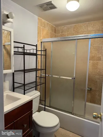 a bathroom with a sink a toilet a mirror and shower