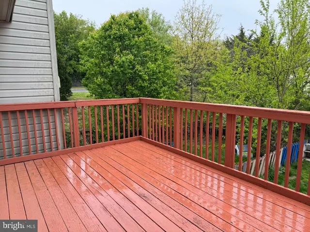 a balcony with wooden floor and trees in the back