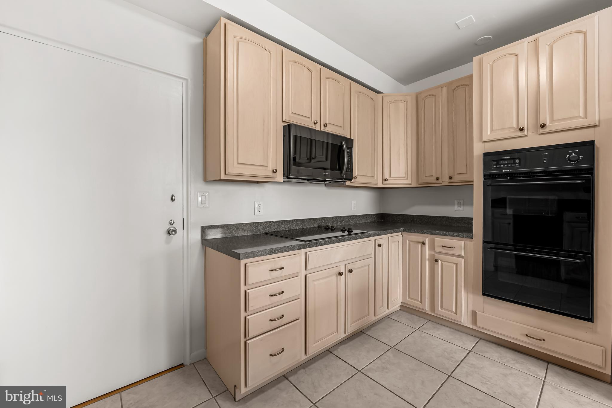 11 Slade Avenue, Unit 911 Baltimore, MD 21208 - Photo 19 of 32 a kitchen with granite countertop white cabinets and stainless steel appliances