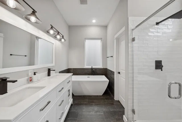 a bathroom with a double vanity sink mirror and shower