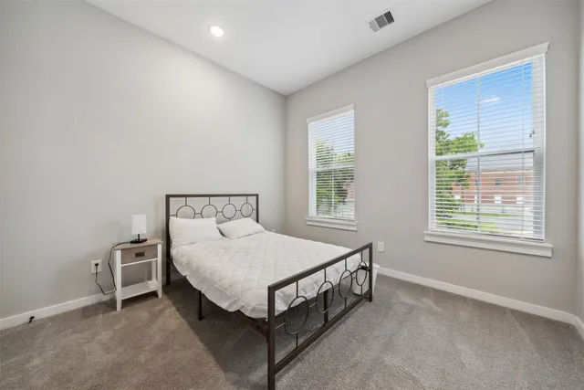 a bed sitting in a bedroom next to a window