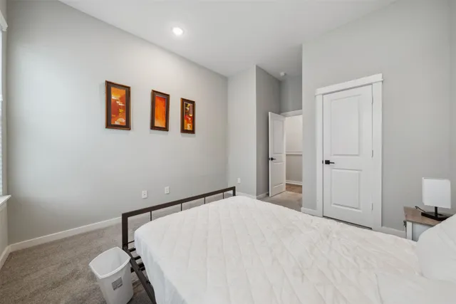 a bedroom with a large bed and a chandelier