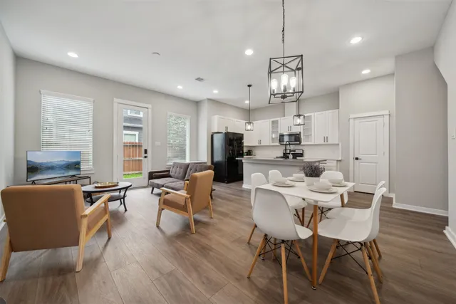 a view of a dining room with furniture a kitchen and chandelier