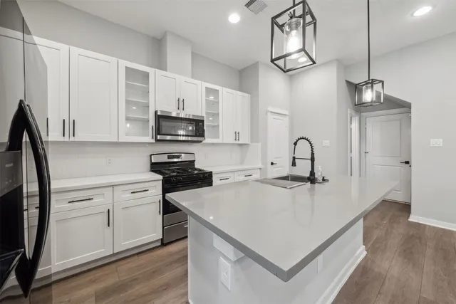 a kitchen with stainless steel appliances granite countertop a sink a stove and a refrigerator