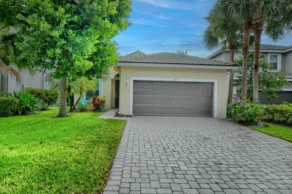 a front view of a house with a garden and garage