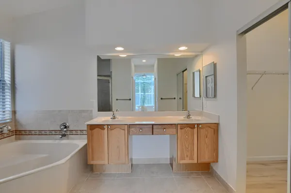 a bathroom with a tub a sink and mirror