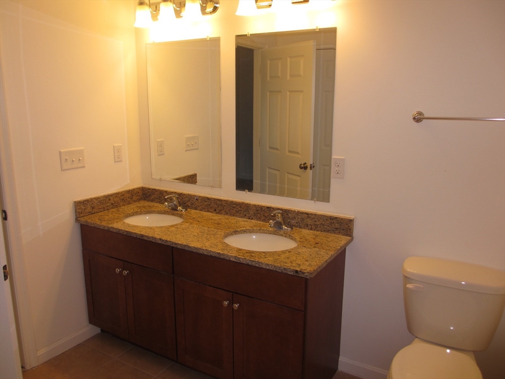 2 Blue Jay Circle, Unit 1 Wakefield, MA 01880 - Photo 5 of 11 a bathroom with a granite countertop sink and a mirror