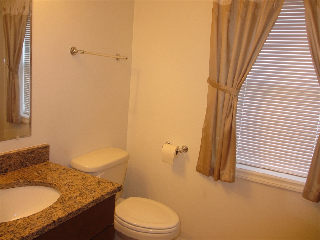2 Blue Jay Circle, Unit 1 Wakefield, MA 01880 - Photo 8 of 11 a bathroom with a granite countertop sink toilet and shower