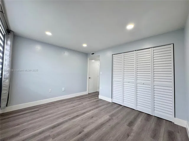 an empty room with wooden floor and white walls