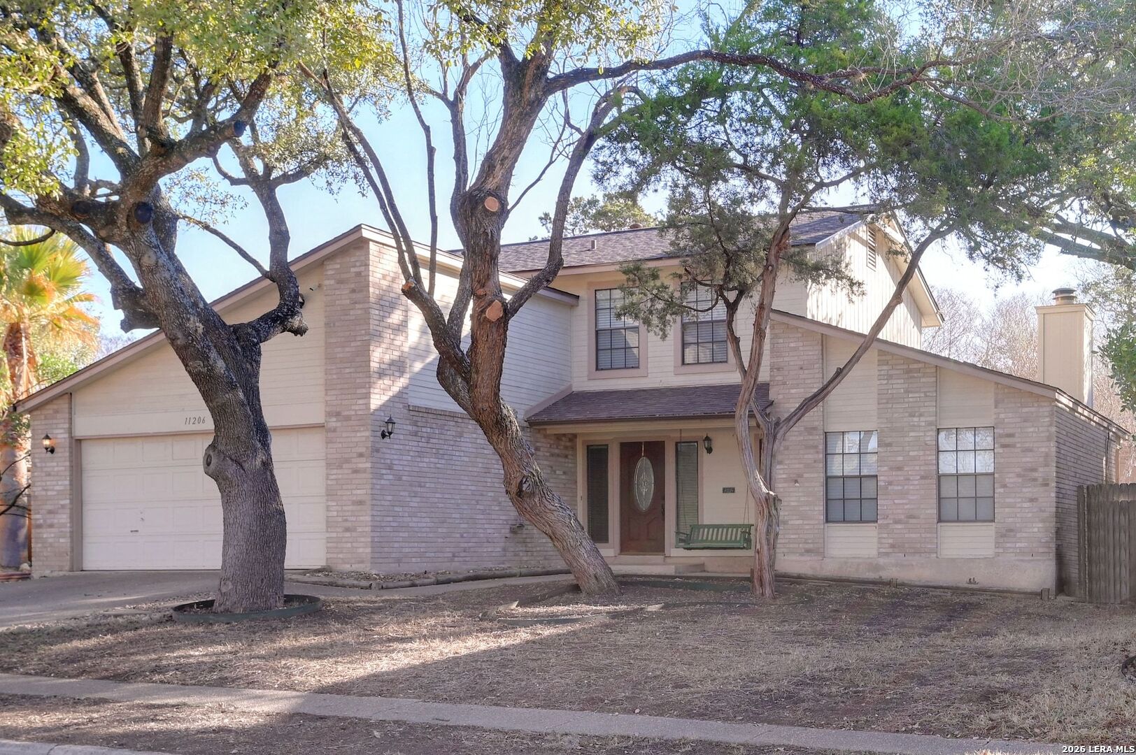 11206 Woodridge Forest San Antonio, TX 78249 - Photo 1 of 1 a white house that has a tree in front of it