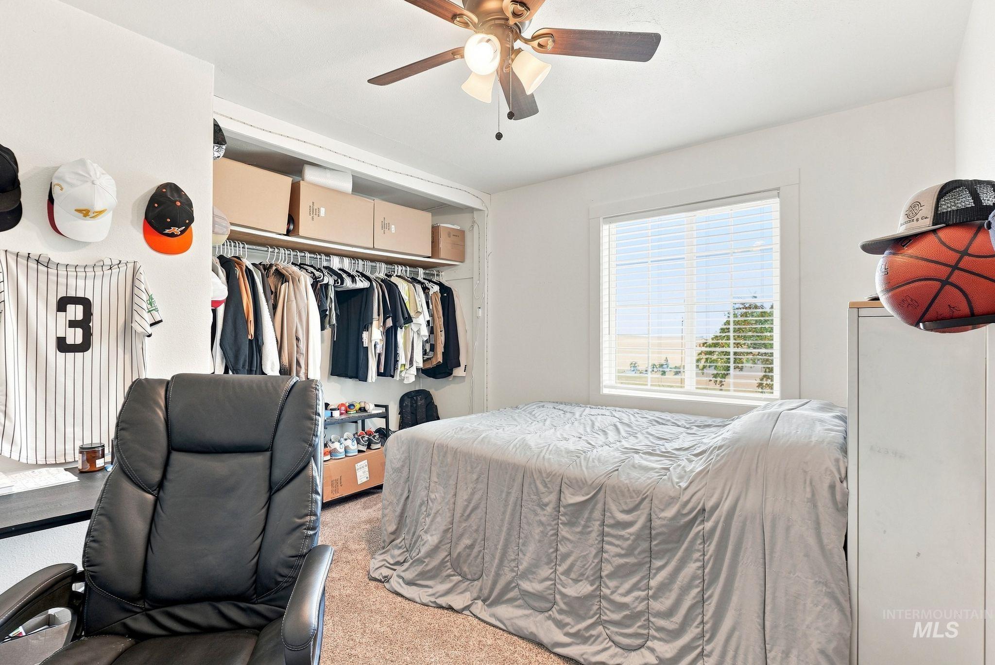 16078 Hoffman Road Kendrick, ID 83537 - Photo 21 of 47 Built-in closet system with upper shelving, window with horizontal blinds, and a ceiling fan with integrated lighting