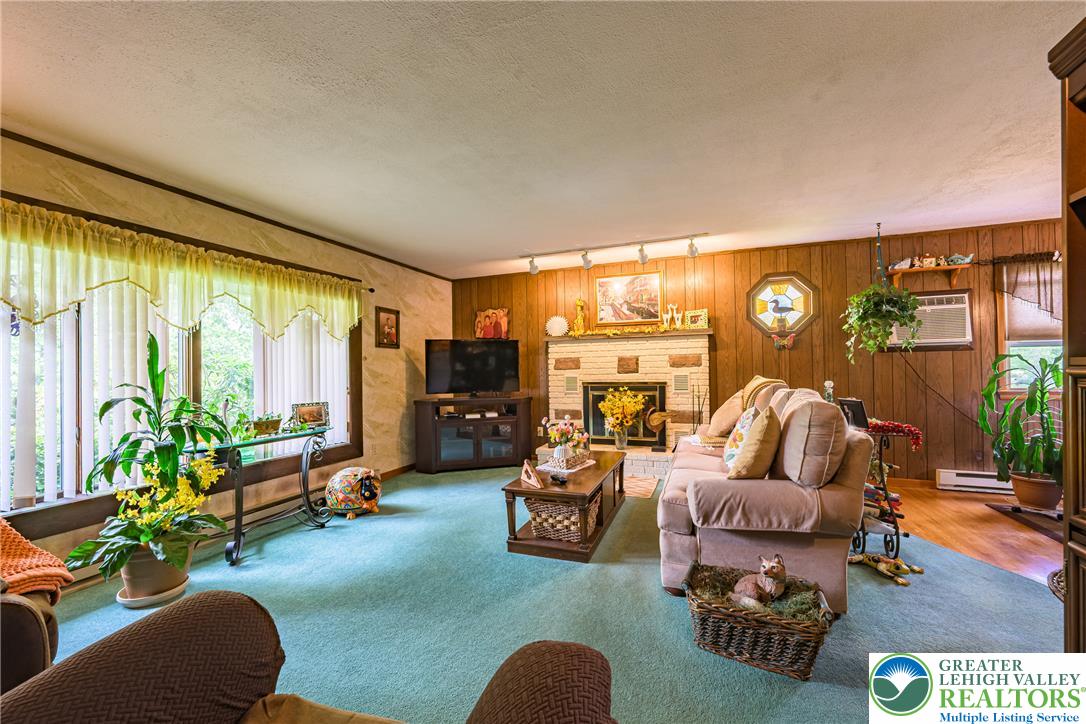 678 Interchange Road Kresgeville, PA 18333 - Photo 20 of 45 A cozy living space features wood paneling and a light-colored brick fireplace.