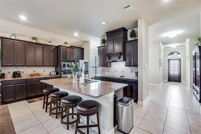 a kitchen with stainless steel appliances granite countertop a sink refrigerator and cabinets