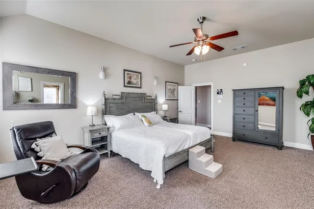 a bedroom with a bed a couch and a chandelier