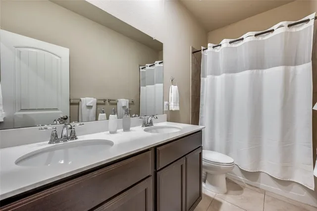 a bathroom with a double vanity sink toilet and a mirror