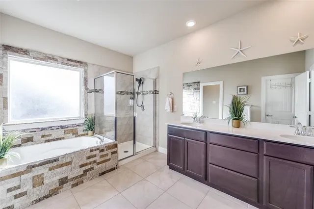 a spacious bathroom with a tub sink and mirror