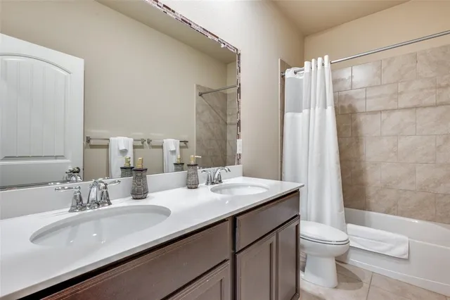 a bathroom with a double vanity sink toilet and a mirror