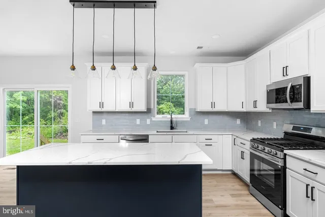 a kitchen with stainless steel appliances a sink stove and cabinets