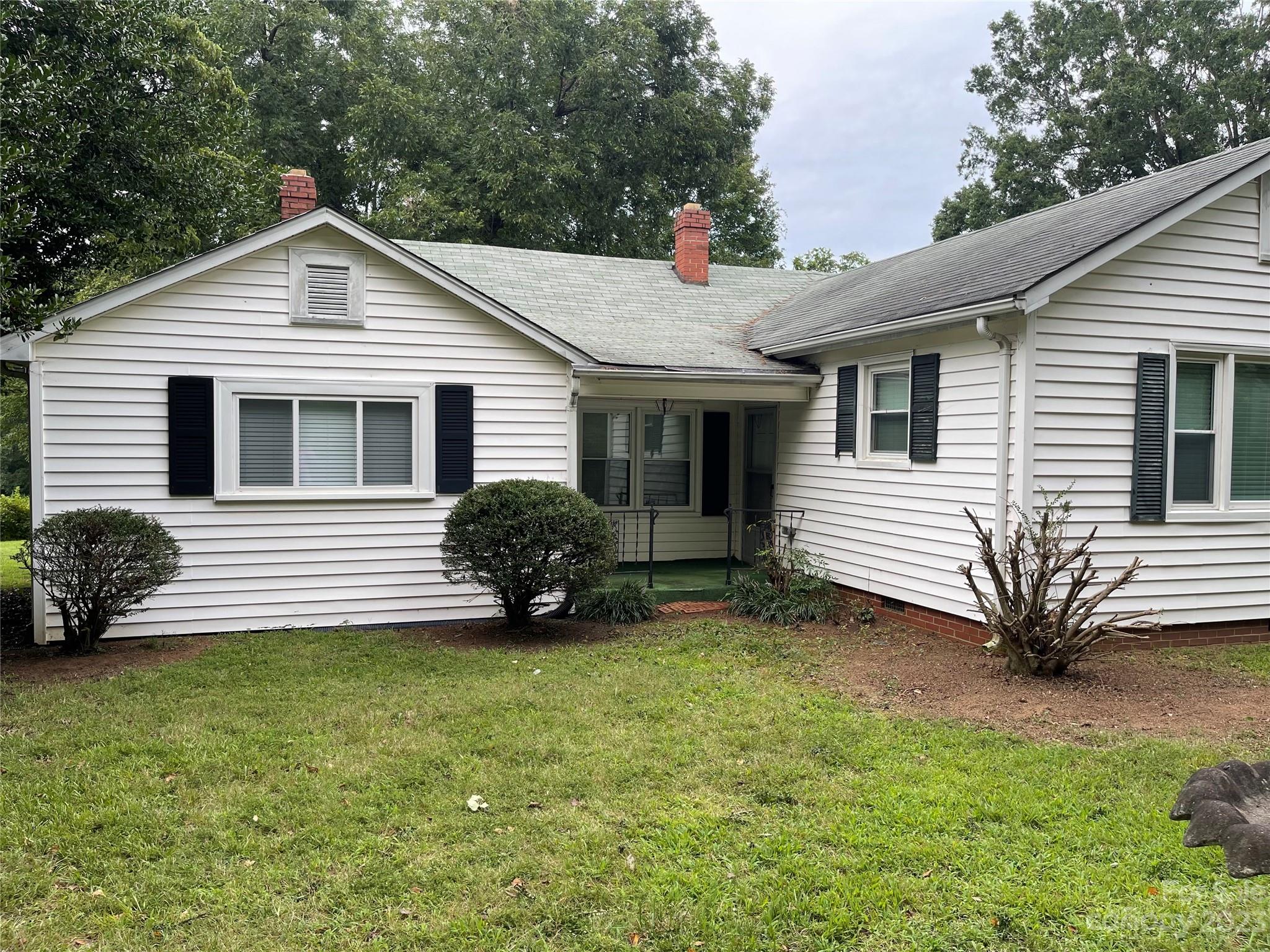a view of a house with a yard and sitting area