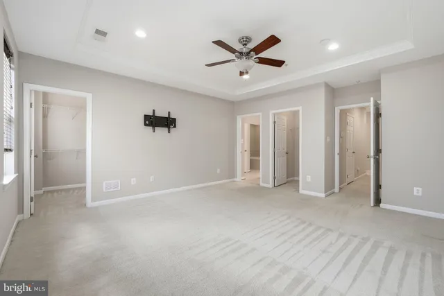 an empty room with closet and a ceiling fan