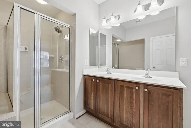 a bathroom with a double vanity sink mirror and shower