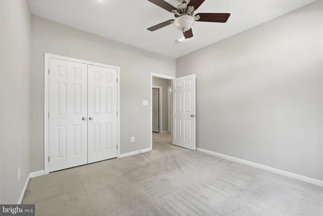 an empty room with a ceiling fan and a window