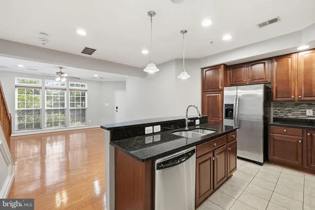 a kitchen with granite countertop a sink and refrigerator