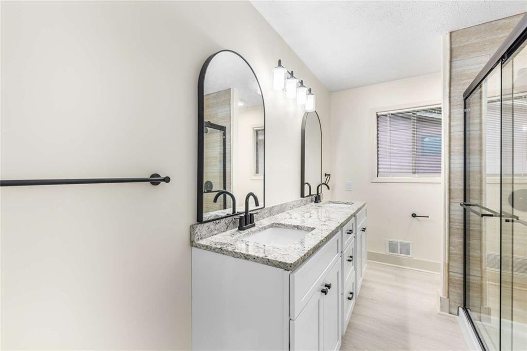 234 Shadow Lake Drive Southwest Lilburn, GA 30047 - Photo 19 of 36 a bathroom with a granite countertop sink and a mirror