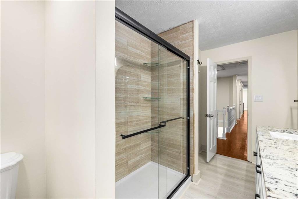 234 Shadow Lake Drive Southwest Lilburn, GA 30047 - Photo 20 of 36 a bathroom with a glass shower door