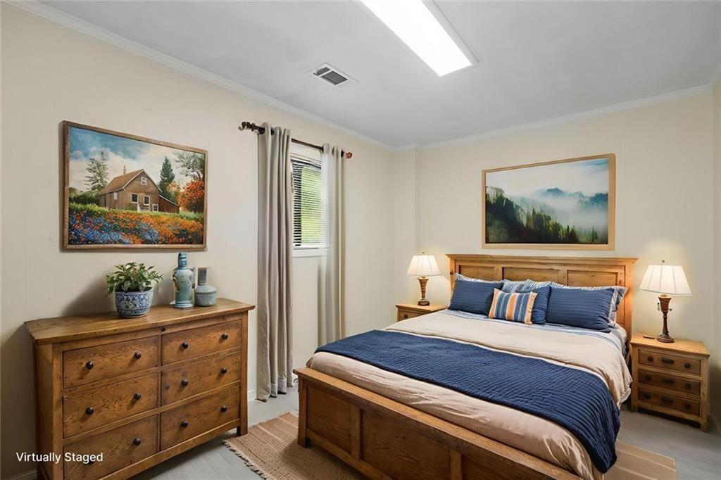 234 Shadow Lake Drive Southwest Lilburn, GA 30047 - Photo 26 of 36 a bedroom with a bed and paintings on the wall