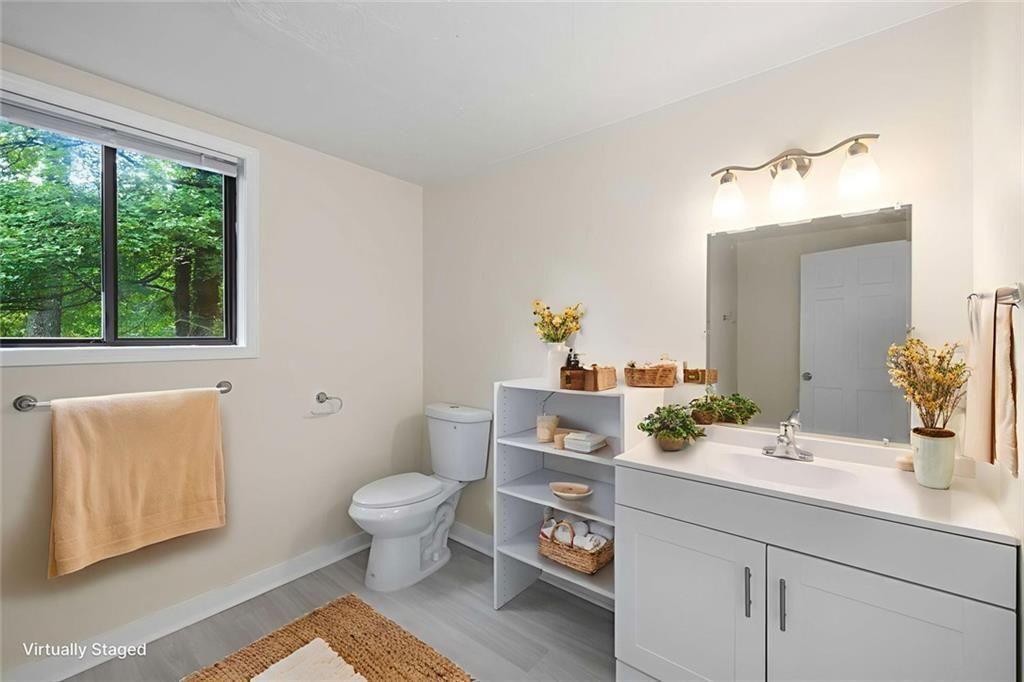 234 Shadow Lake Drive Southwest Lilburn, GA 30047 - Photo 27 of 36 a bathroom with a sink a toilet and a window