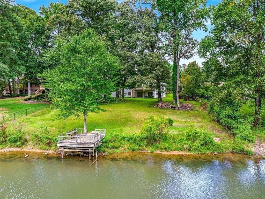 234 Shadow Lake Drive Southwest Lilburn, GA 30047 - Photo 32 of 36 a view of a lake with a big yard and large trees