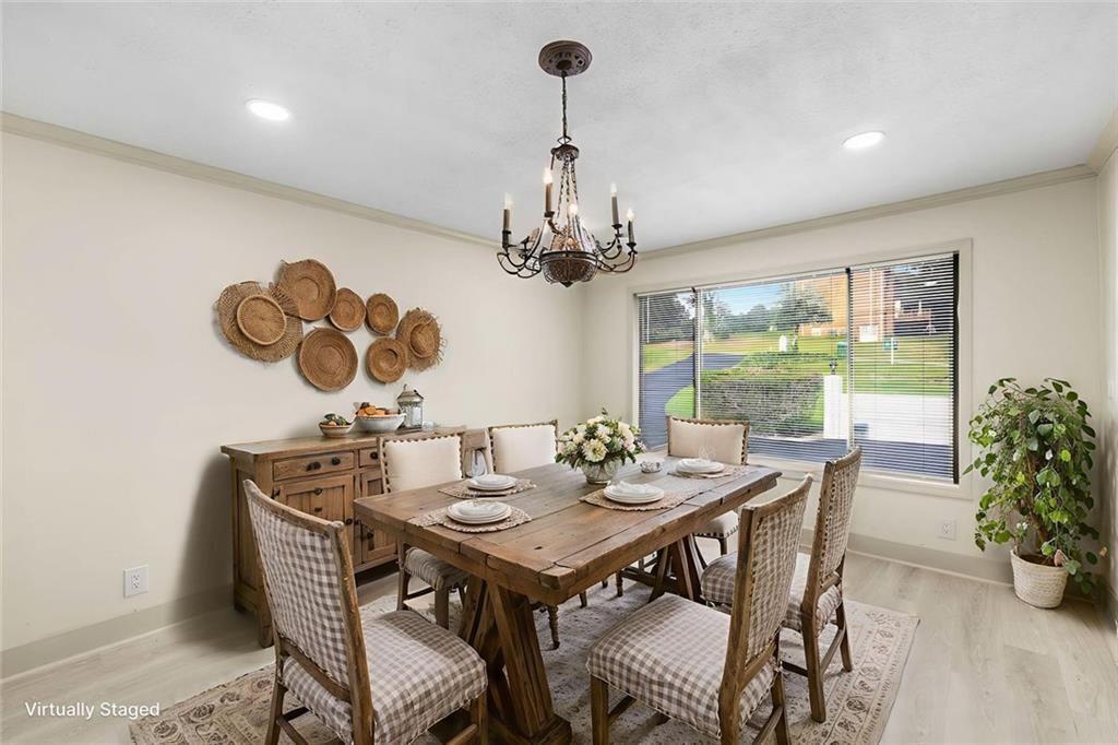 234 Shadow Lake Drive Southwest Lilburn, GA 30047 - Photo 6 of 36 a view of a dining room with furniture a chandelier and wooden floor
