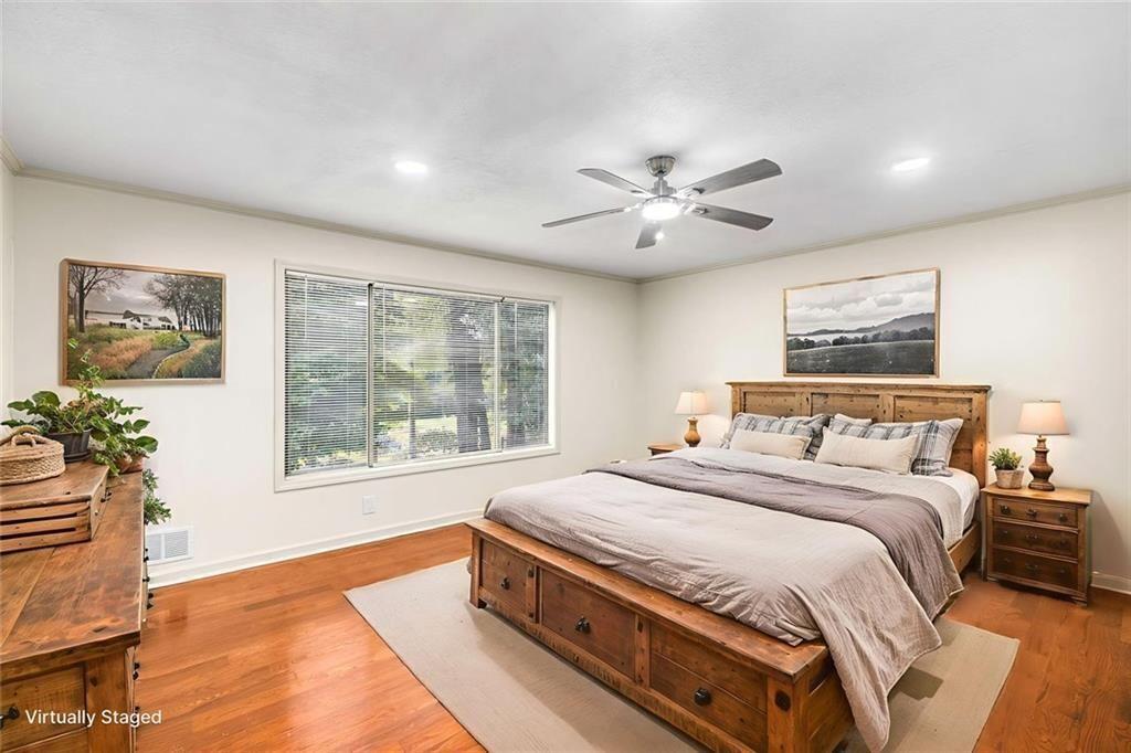 234 Shadow Lake Drive Southwest Lilburn, GA 30047 - Photo 7 of 36 a spacious bedroom with a large bed and a chandelier