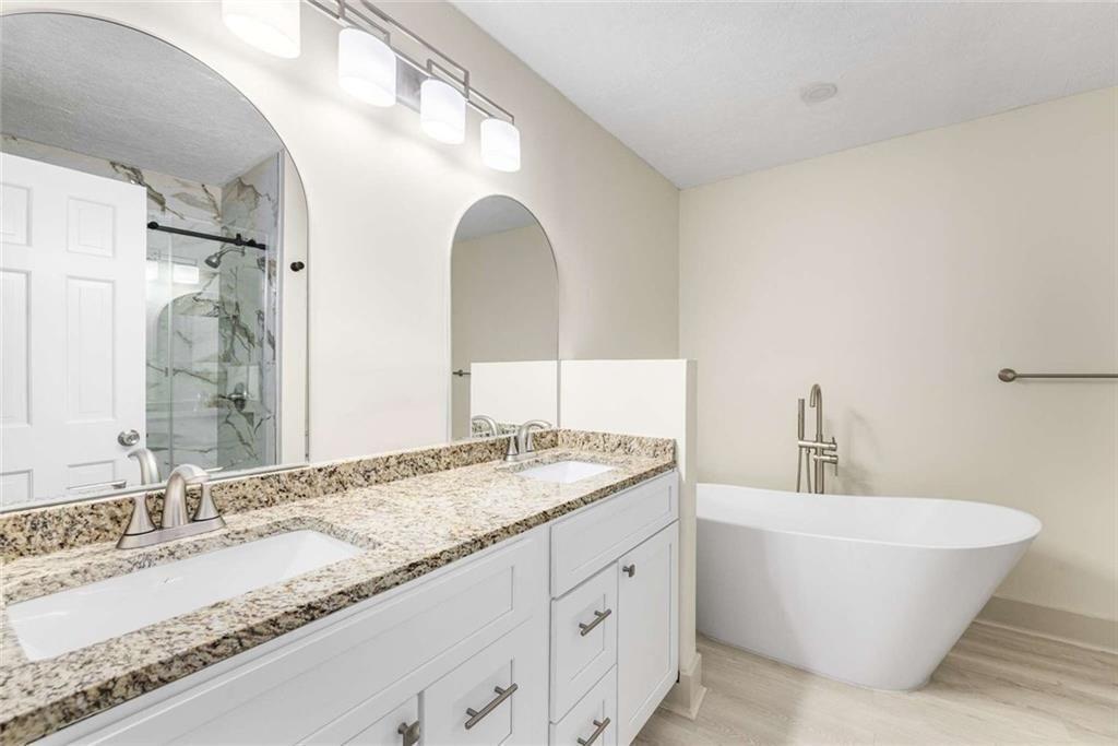 234 Shadow Lake Drive Southwest Lilburn, GA 30047 - Photo 8 of 36 a bathroom with a granite countertop sink and a mirror