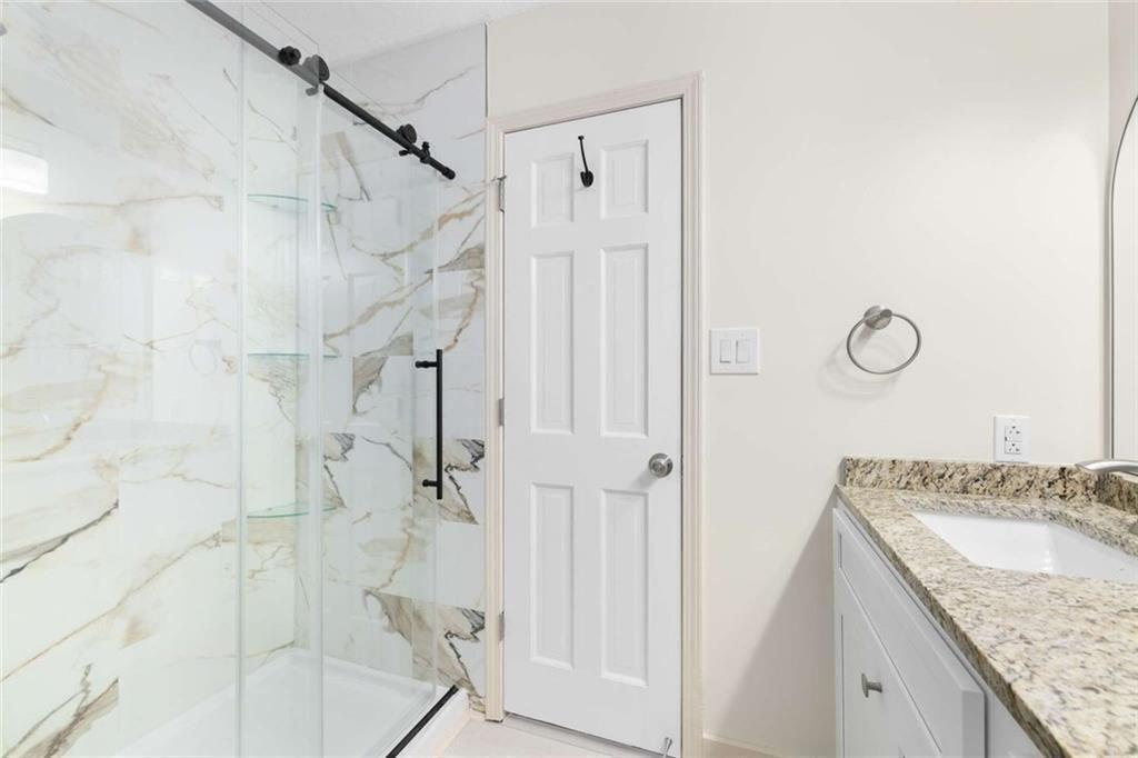 234 Shadow Lake Drive Southwest Lilburn, GA 30047 - Photo 9 of 36 a bathroom with a granite countertop shower sink and vanity