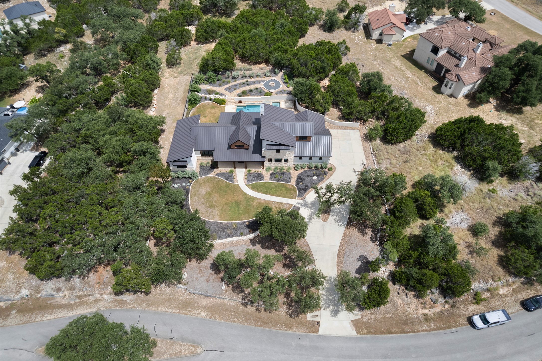 27619 Sunset Loop Garden Ridge, TX 78266 - Photo 33 of 39 An aerial perspective reveals the metal roofline and sprawling layout nestled among dense mature trees.