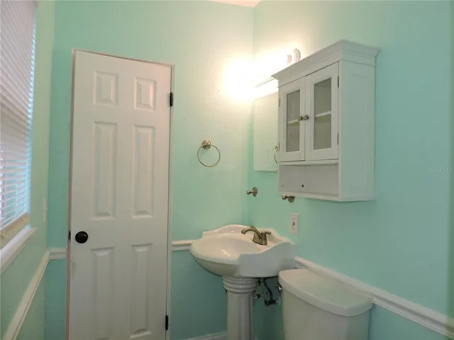 a bathroom with a sink a toilet and mirror