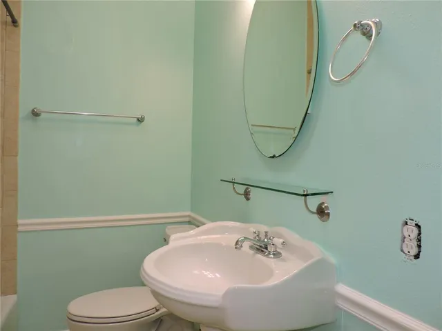 a bathroom with a sink toilet and a mirror