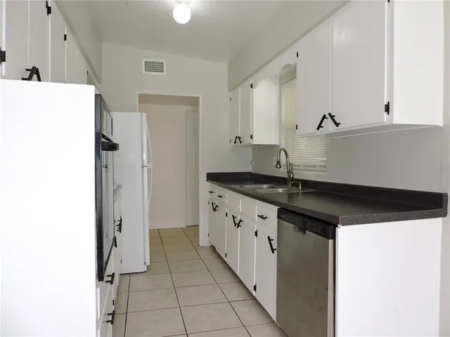 a kitchen with granite countertop a sink and cabinets